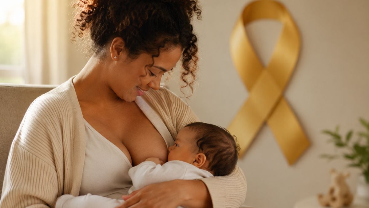 Agosto Dourado: mãe amamentando com ternura enquanto amamenta o bebê no colo, em ambiente acolhedor, simbolizando proteção ao recém-nascido e fortalecimento do vínculo