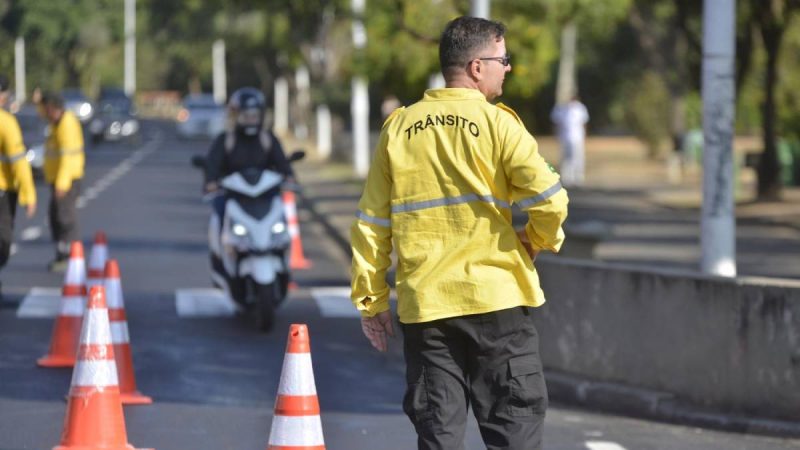 curso de agente de trânsito em Indaiatuba: Indaiatuba forma novos agentes de trânsito e amplia fiscalização e segurança nas ruas, com um agente ao fundo orientando o tráfego em via urbana sinalizada com cones