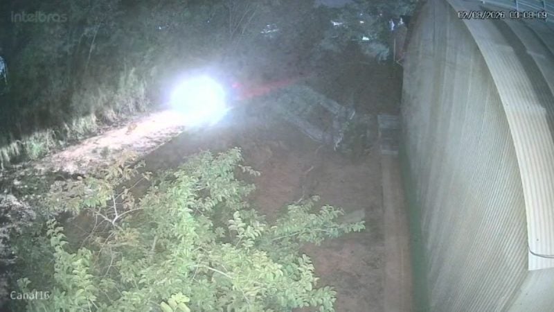 advogado Lucas Lopes: Imagem de vídeo em ambiente externo com vegetação e luz forte ao fundo, mostrando um caminho percorrido por um suspeito após a morte de advogado, em registro de câmeras de segurança.