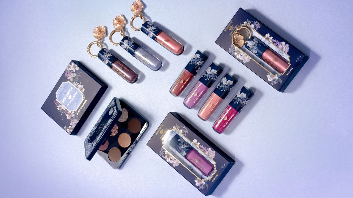 Bruna Tavares transforma universo de Bridgerton em coleção de maquiagem: vários kits e glosses em embalagens azul e dourada com flores, organizados sobre fundo claro.