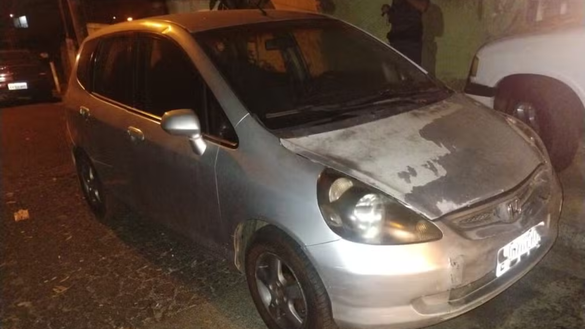 Apreensão de carro com 438 multas e 85 mil em débitos em Limeira: veículo estacionado e detido à noite, com faróis acesos e equipe ao fundo