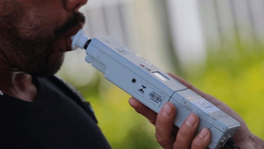 Lei Seca: Fiscalização de trânsito com uso de Drogômetro: exame preliminar identifica substâncias psicoativas por amostra de saliva, com aparelho sendo aplicado durante abordagem.