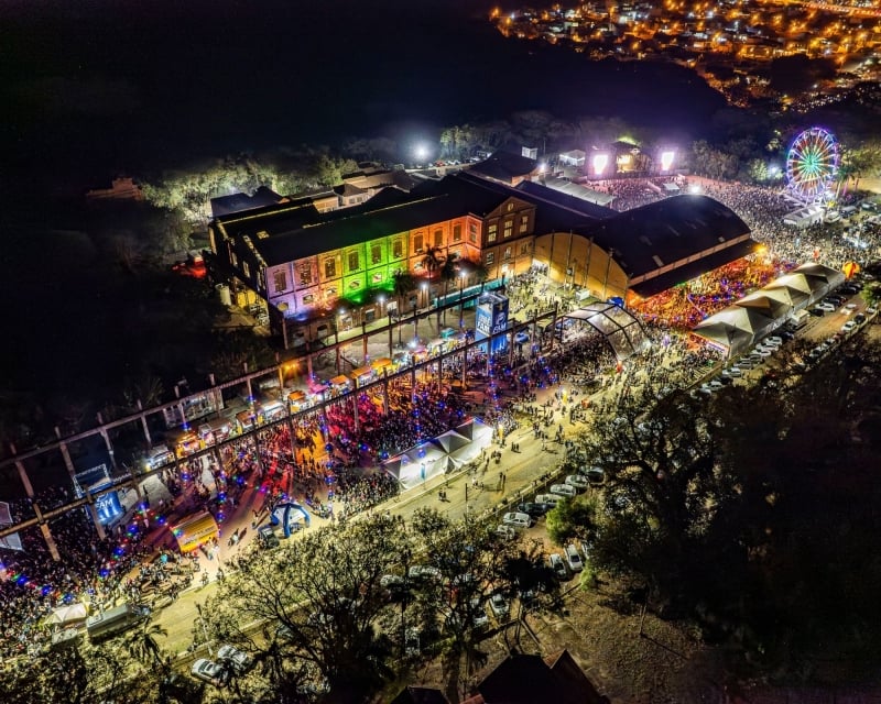 Vista aérea à noite do Santa Bárbara Rock Fest 2026, com grande área de shows, luzes e público circulando, além de roda-gigante e estruturas iluminadas.