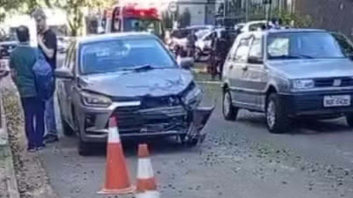 homem e filha ficam feridos após acidente: Acidente entre carro e moto em Campinas: equipe e veículos no local, com cones sinalizando a via e duas pessoas feridas após colisão.