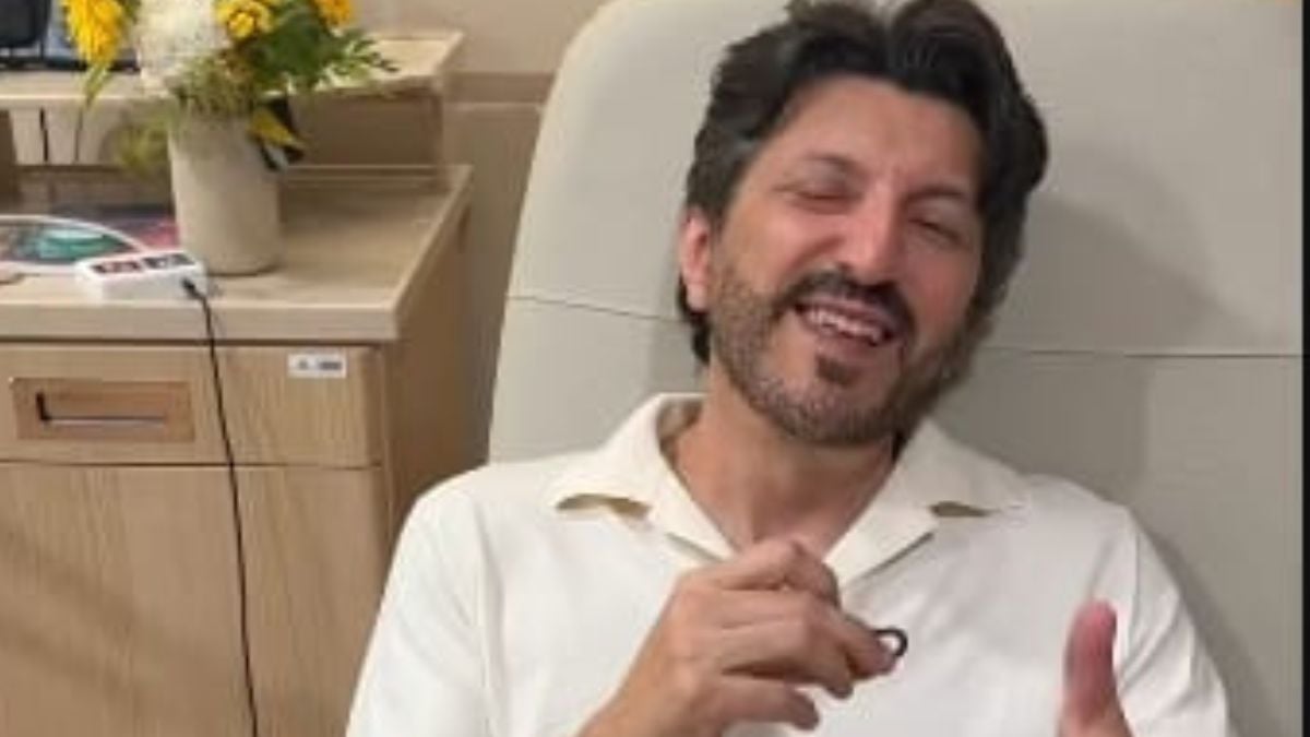 Lito Souza aparece sorrindo em ambiente interno, sentado ao lado de móveis de escritório, em contexto de relato sobre diagnóstico de doença rara e perda de movimentos.