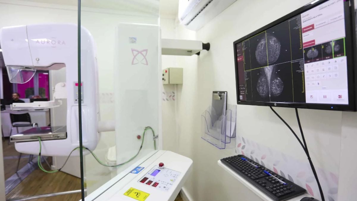 Carreta da Mamografia em Peruíbe: sala de atendimento com mamógrafo, painel de monitor exibindo imagens de exames e equipamentos para rastreamento de câncer de mama