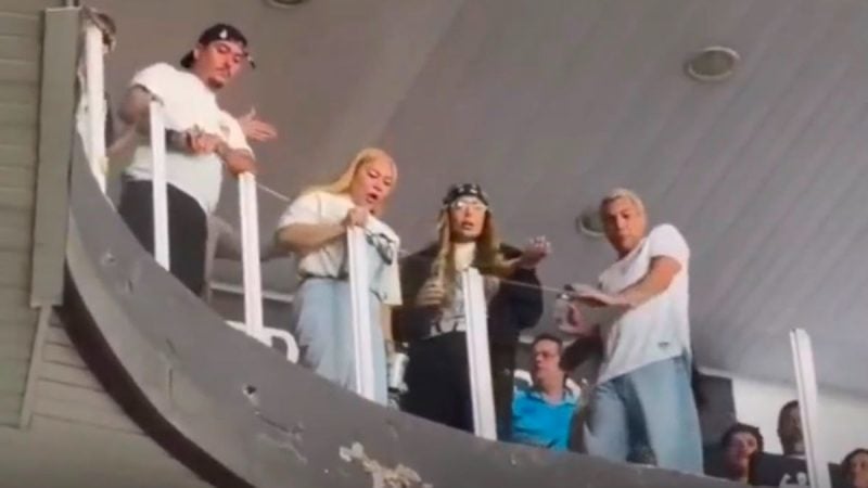 Irmã de Neymar aparece em um estádio, nas arquibancadas da Vila Belmiro, enquanto torcedores arremessam objetos e fazem xingamentos durante uma partida.