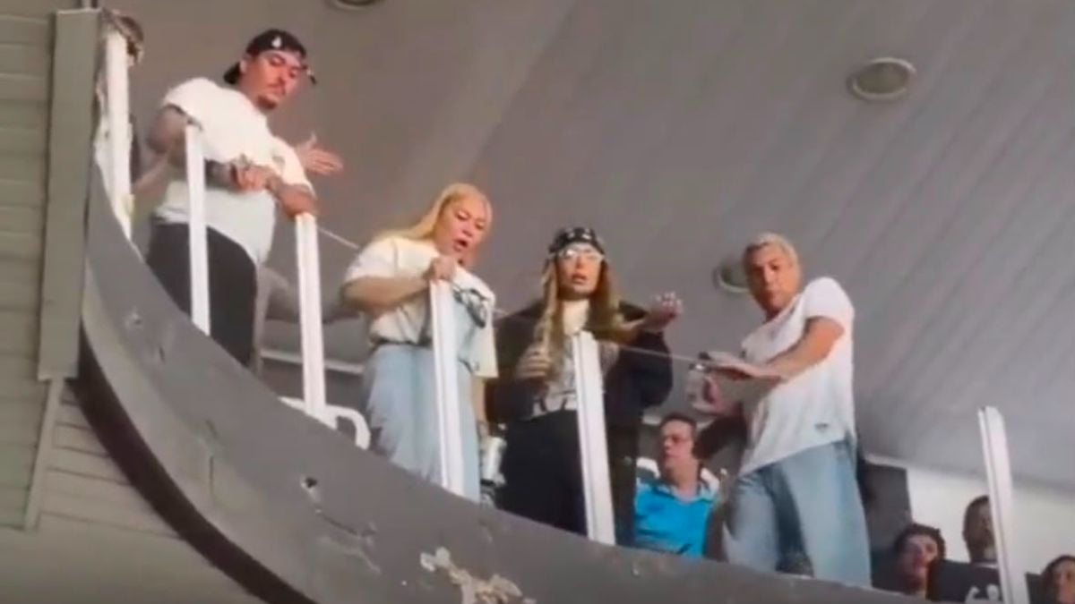 Irmã de Neymar aparece em um estádio, nas arquibancadas da Vila Belmiro, enquanto torcedores arremessam objetos e fazem xingamentos durante uma partida.