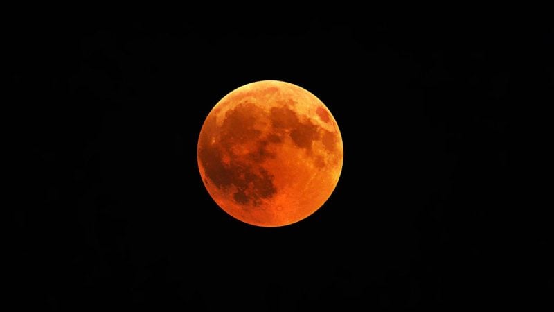 Eclipse lunar no Brasil: lua em tom avermelhado com atmosfera escura ao fundo, indicando um eclipse lunar visível em diferentes regiões do país nesta sexta-feira.