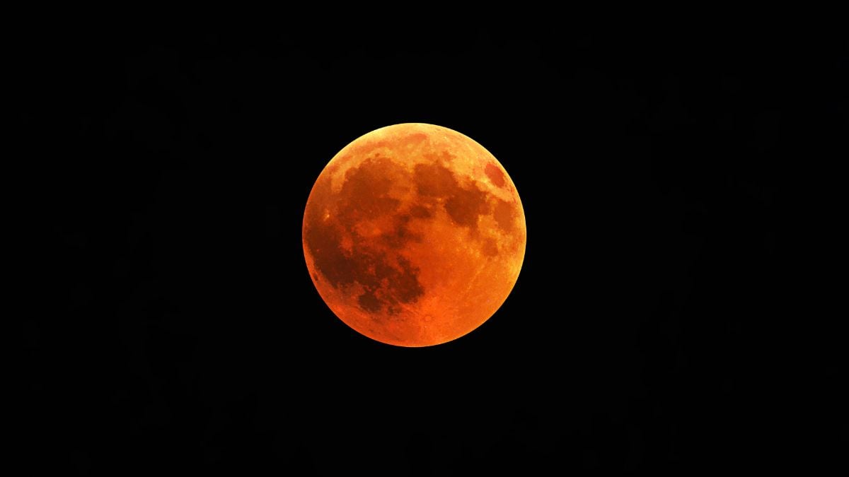 Eclipse lunar no Brasil: lua em tom avermelhado com atmosfera escura ao fundo, indicando um eclipse lunar visível em diferentes regiões do país nesta sexta-feira.