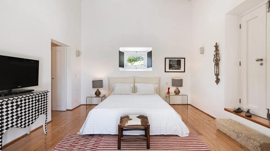 Imani Country House: quarto claro e elegante com cama king, paredes brancas, poltronas laterais e iluminação suave, em um refúgio no Alentejo perto de Évora.