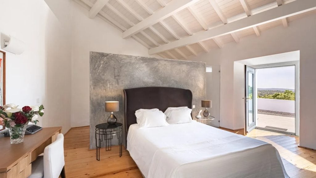 Imani Country House: quarto de casal com cama king size, paredes em cimento aparente e saída para varanda, em refúgio de charme no Alentejo perto de Évora
