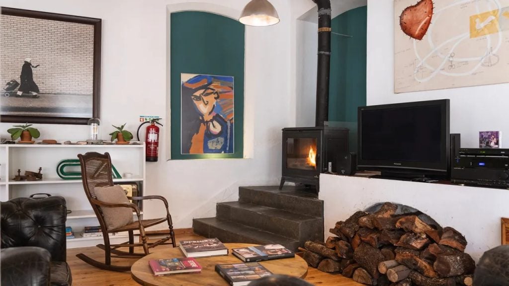 Imani Country House: sala de estar com lareira, cadeiras confortáveis e decoração de charme no Alentejo, perto de Évora