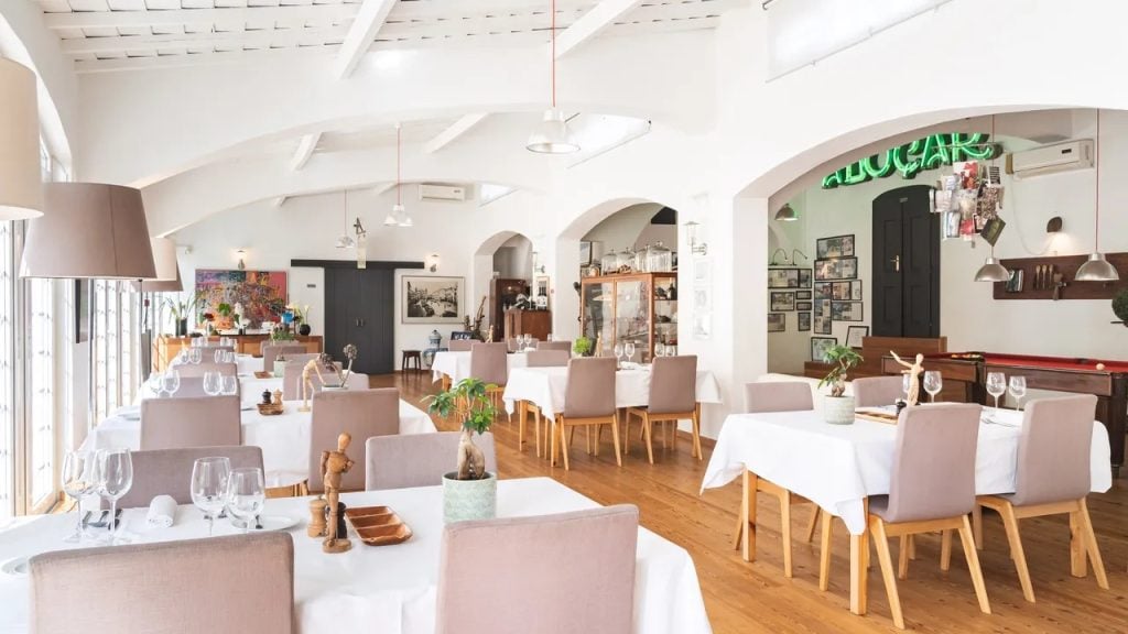 Imani Country House: interior de um espaço de refeições com mesas e cadeiras, decoração em tons claros e atmosfera acolhedora no Alentejo perto de Évora.