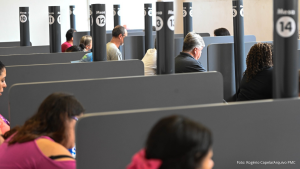 Pessoas atendem em guichês numerados dentro de um espaço de serviços públicos no Shopping Parque das Bandeiras, em Campinas. Loja do Cidadão Campinas
