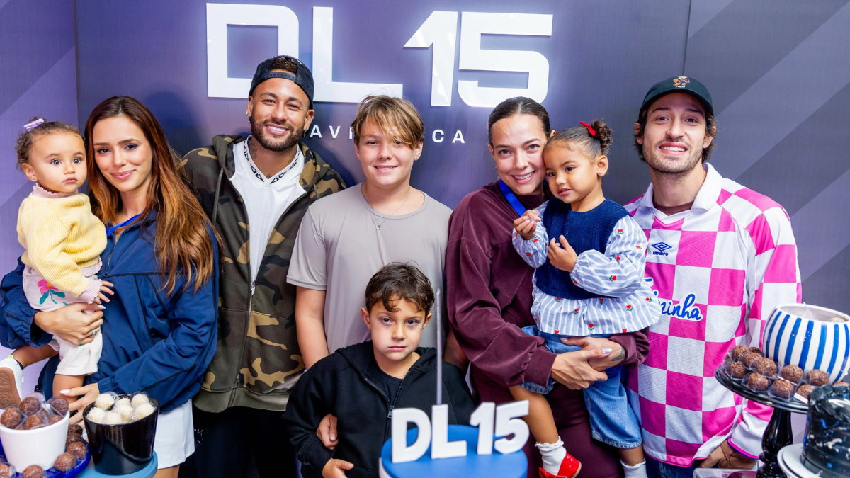 Davi Lucca 15 anos: Neymar e família reunidos na festa de 15 anos de Davi Lucca, com o aniversariante ao centro, ao lado de adultos e crianças diante de uma parede com a marca DL15.