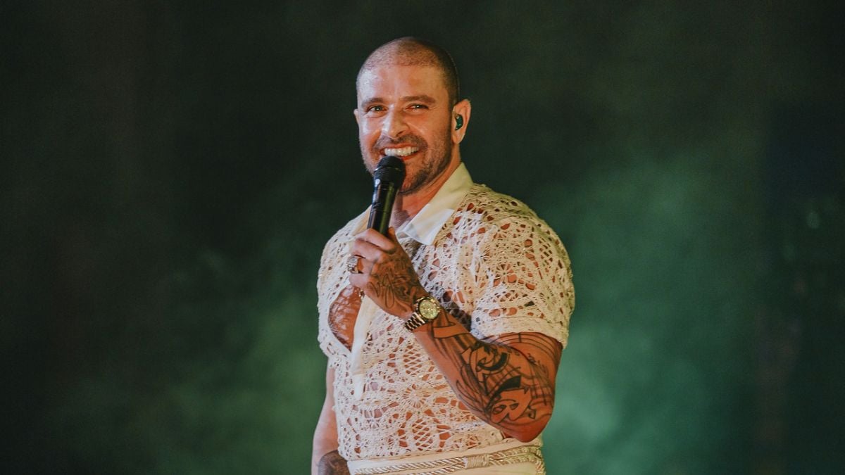 Diogo Nogueira cantando ao vivo no palco com microfone, em evento de setembro, abrindo a Semana Cultural de Hortolândia; confira a programação.
