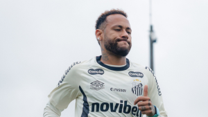 Neymar em treino usando uniforme do Santos, com expressão séria, em destaque na imagem; a nota indica que Neymar não deve jogar o clássico contra o Palmeiras.