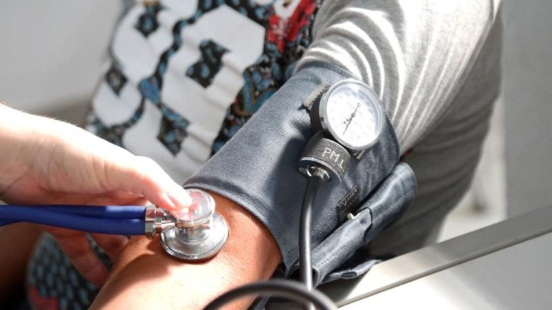 Medição de pressão arterial com estetoscópio e braçadeira, em ação de prevenção e conscientização do setembro vermelho em Limeira para doenças cardiovasculares.