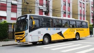 Ônibus da São Vicente com portas e janelas fechadas em via urbana, com comunicação de gratuidade na catraca para o dia de Parada Cívica, em São Vicente.