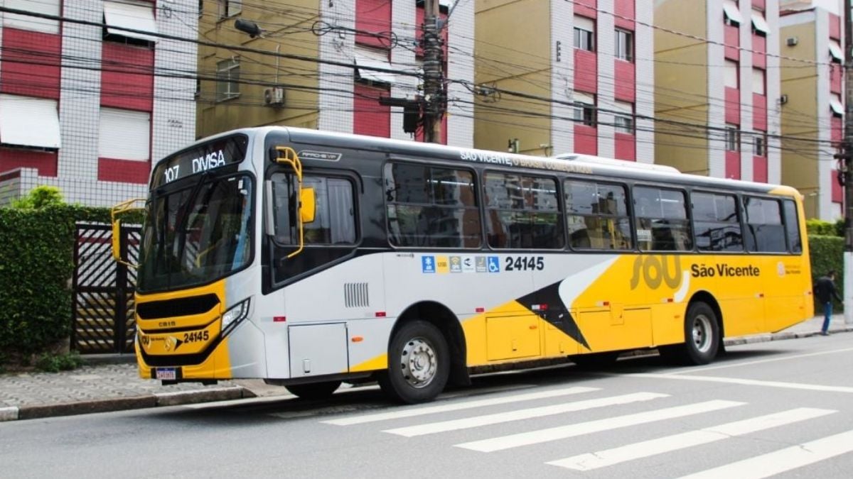 Ônibus da São Vicente com portas e janelas fechadas em via urbana, com comunicação de gratuidade na catraca para o dia de Parada Cívica, em São Vicente.