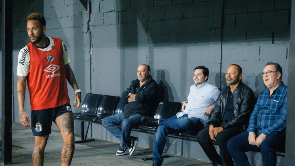 Neymar em treino do Santos, acompanhado por Marcelo Teixeira, presidente do clube, e outras pessoas ao fundo em foto do Santos FC; Santos dívida Neymar.