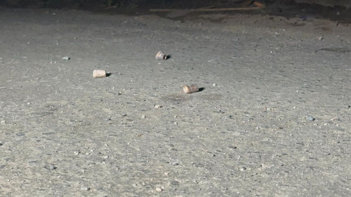 Pequenos fragmentos de material espalhados sobre o chão de concreto, em uma cena com superfície áspera e sujeira visível.