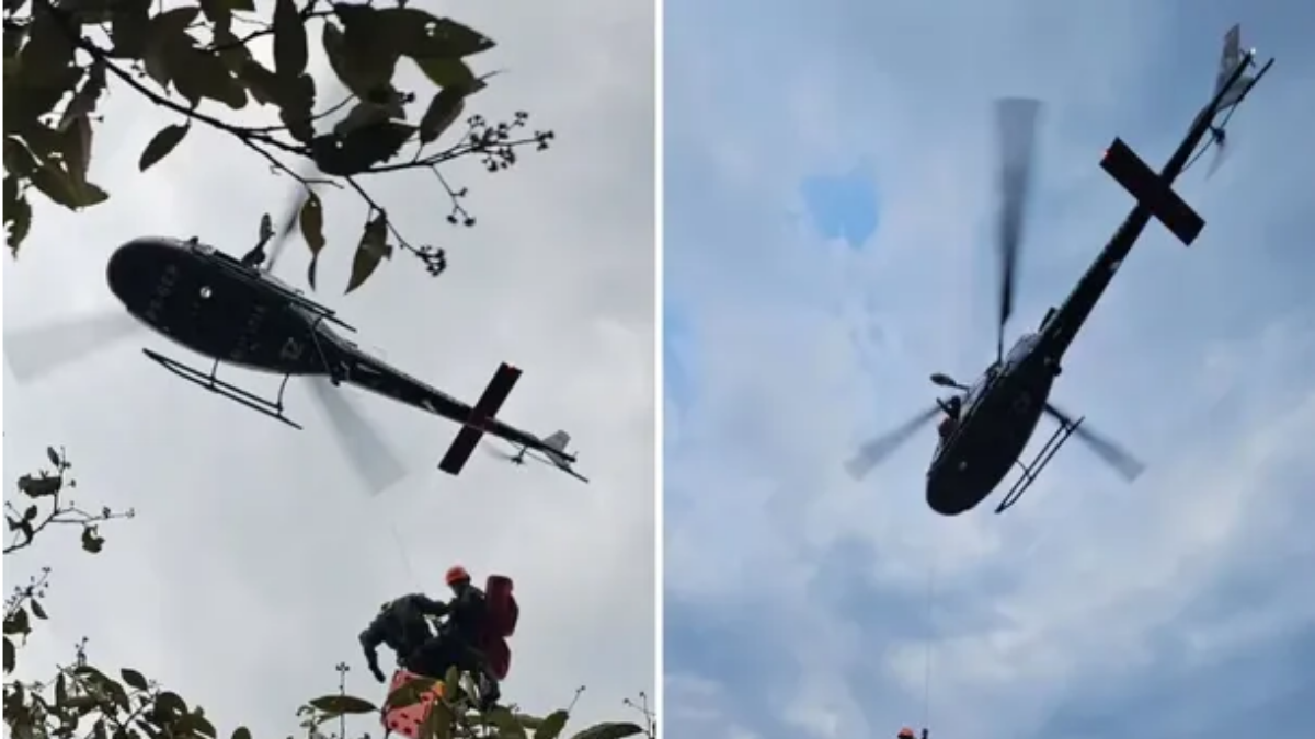 Trilha Pedra Grande em Atibaia: equipe de resgate suspensa por helicóptero atende trilheiro ferido no tornozelo durante operação em área de mata, com o céu ao fundo