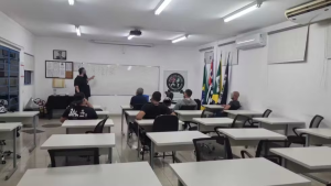 Sala de aula com participantes sentados e um instrutor em pé, em programa de Santa Bárbara d’Oeste voltado à reeducação de autores de violência contra mulheres, Tempo de Superação.