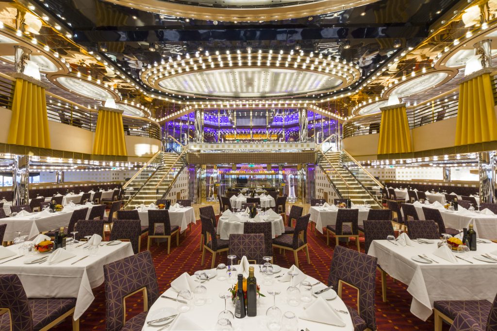 Interior do navio Costa Diadema com mesas de jantar postas e iluminação sofisticada, ideal para promover a temporada de cruzeiros 2026/2027.