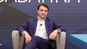 Renan Santos em entrevista ou evento político, sentado em palco com microfone, em contexto sobre as Eleições 2026 e a suspensão da campanha pelo TSE, ficando proibido de ir a debates.