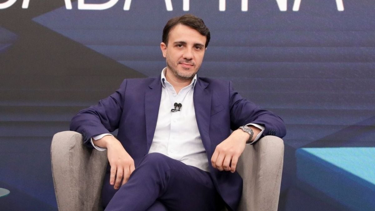 Renan Santos em entrevista ou evento político, sentado em palco com microfone, em contexto sobre as Eleições 2026 e a suspensão da campanha pelo TSE, ficando proibido de ir a debates.