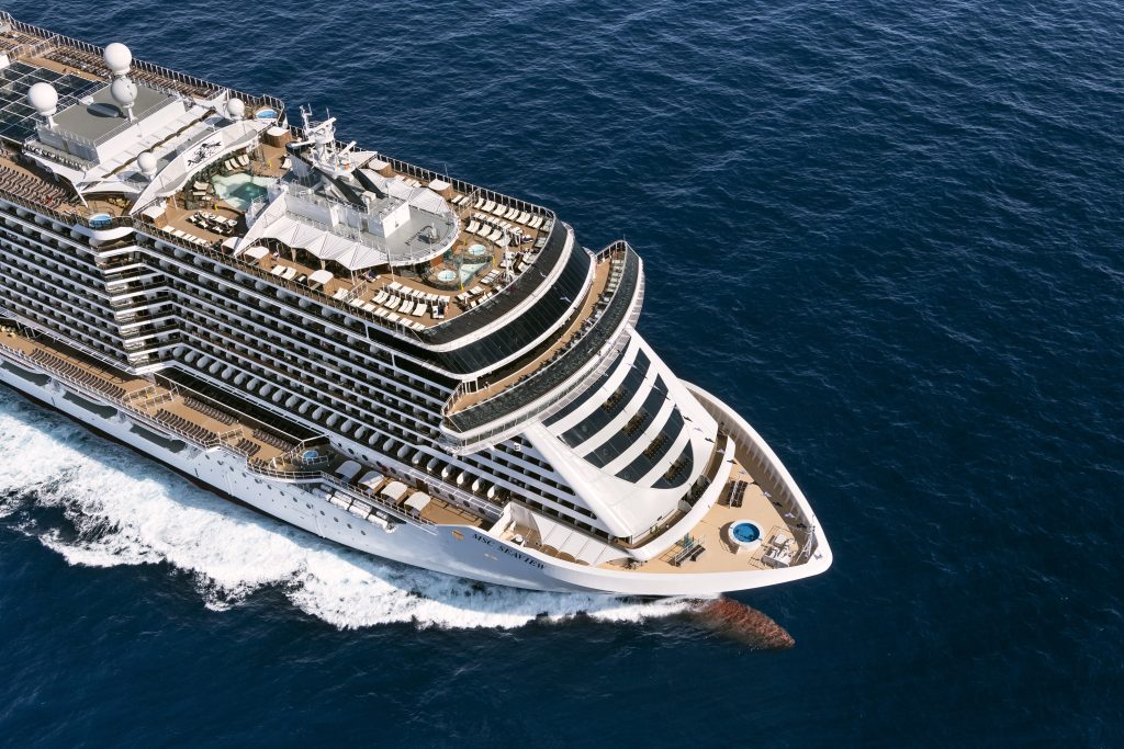 temporada de cruzeiros 2026/2027: Vista aérea do navio de cruzeiro MSC Seaview com o Odeon Theatre, navegando sobre o mar em águas azul-escuras.