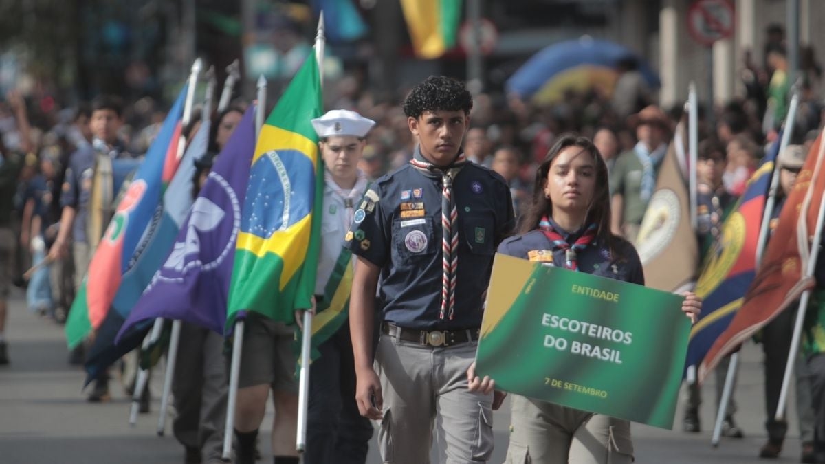 Desfile cívico Campinas no 7 de setembro, com jovens e bandeiras do Brasil ao fundo em uma marcha cívica na cidade.