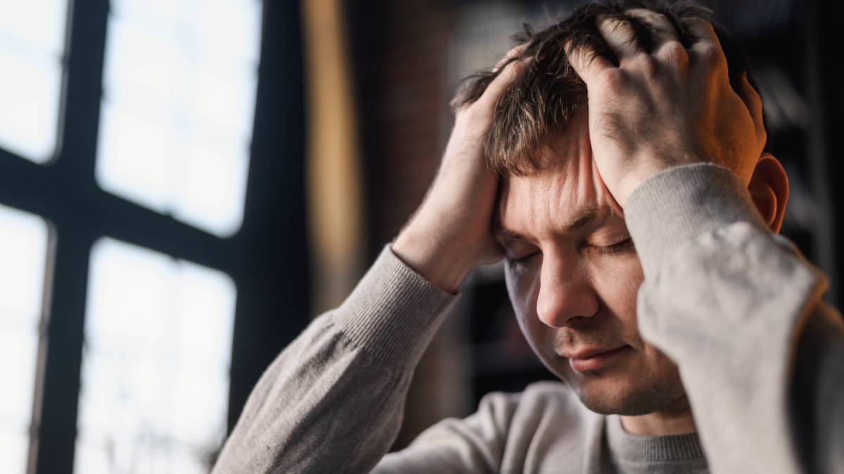 Setembro Amarelo: homem com as mãos na cabeça e expressão de preocupação, em alerta para atitudes que podem indicar crise de saúde mental e necessidade de apoio.