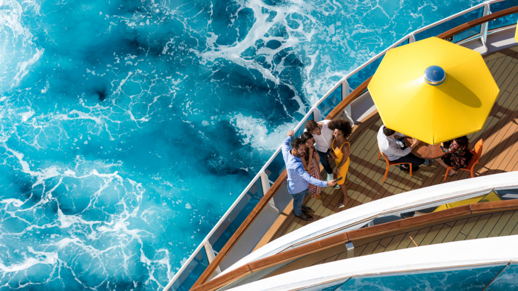 Costa Cruzeiros em Santos: Costa Diadema em cruzeiro, com passageiros em um deque ao lado do mar azul e ondas próximas ao navio, cenário de viagem e lazer a bordo.