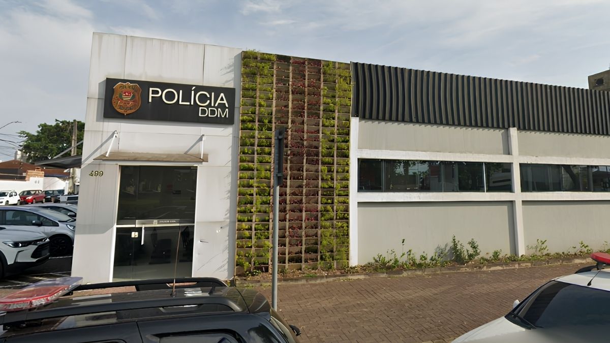 Fachada da Polícia DDM em Praia Grande, com placa “Polícia DDM” e entrada da delegacia, em destaque na notícia sobre o funcionamento 24h. DDM de Praia Grande