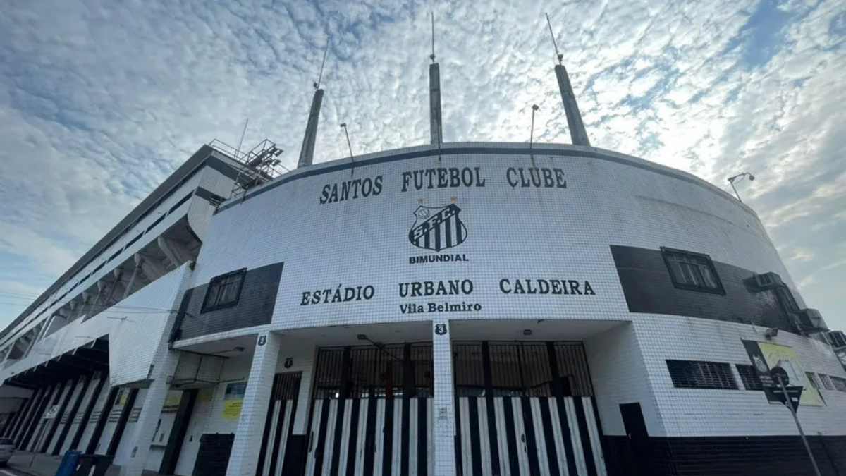 Fachada do Estádio Urbano Caldeira, do Santos Futebol Clube, com céu nublado ao fundo; contexto sobre SAF no Santos e proposta apresentada à espera de resposta do clube.