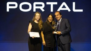 Top of Mind VTV: equipe da agência Portal Publicidade posa em evento de premiação com troféu e certificados ao lado de representantes, diante do logo PORTAL em fundo azul escuro