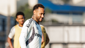 Neymar em treino do Santos, sorridente e com uniforme branco e listras, durante preparação para o clássico contra o Palmeiras no estádio.