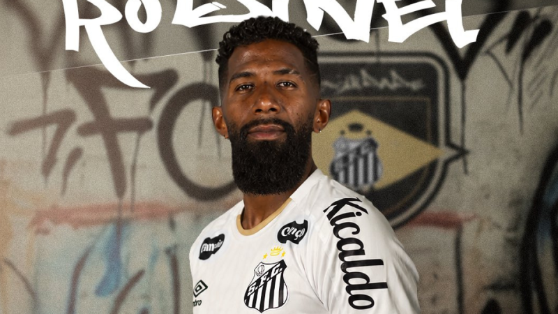 Rodinei aparece em foto de apresentação com camisa do Santos, em anúncio de contratação do lateral-direito até o final de 2027, com fundo grafitado e logotipo do clube.