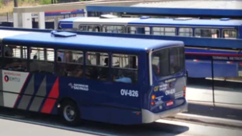Ônibus urbano azul circulando em via pública, com faixa de identificação na lateral; a imagem remete a matérias sobre artesp apontando irregularidades e risco de perda de contrato na região