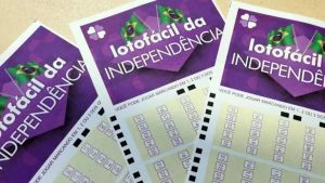 Caixas de loteria Lotofácil da Independência, com cartões roxos e instruções de jogo marcando os números na cartela.