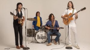 Espetáculo Beatles Abbey Road – O Tributo Definitivo aos Beatles com músicos em estúdio ao lado de bateria com logo “The Beatles” e guitarras em performance