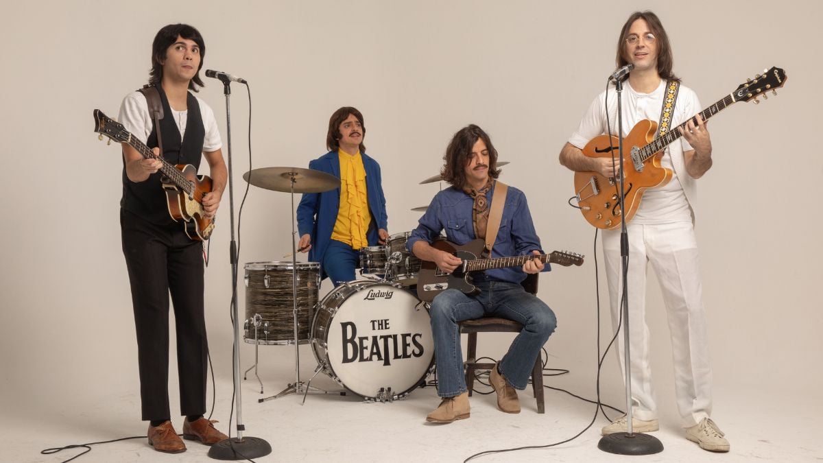 Espetáculo Beatles Abbey Road – O Tributo Definitivo aos Beatles com músicos em estúdio ao lado de bateria com logo “The Beatles” e guitarras em performance