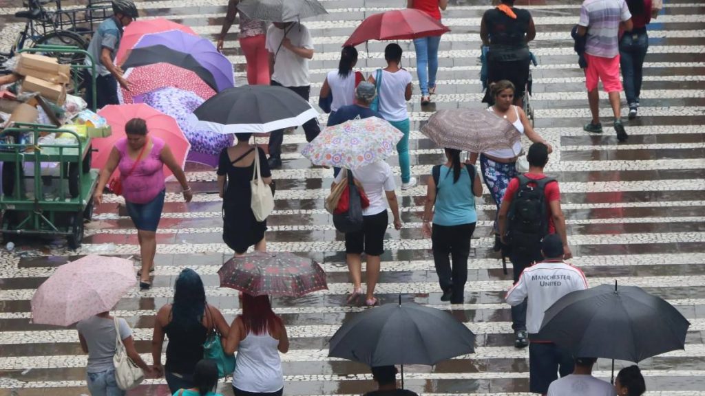Chuva em SP: pessoas caminhando com guarda-chuvas em escadaria durante o tempo chuvoso em São Paulo, com previsão de melhora no fim de semana