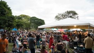 Público reunido em festival da cerveja de Barão, com barracas e tendas ao ar livre, pessoas conversando e a área do evento lotada ao fim da tarde.