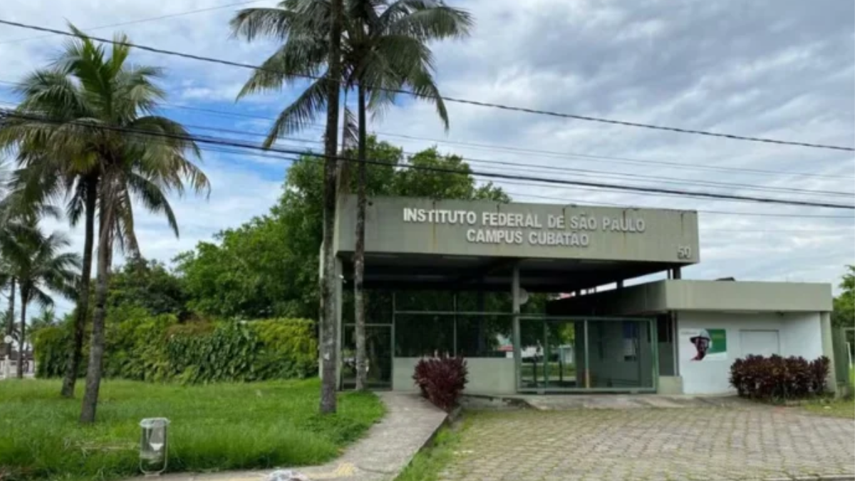 Entrada do Instituto Federal de São Paulo, Campus Cubatão, com fachada, jardim e palmeiras ao fundo, sob céu nublado.