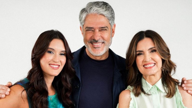 William Bonner aparece sorridente no centro da imagem, com duas mulheres ao lado, em uma foto de divulgação relacionada a fala sobre divórcio de Fátima Bernardes após 10 anos.