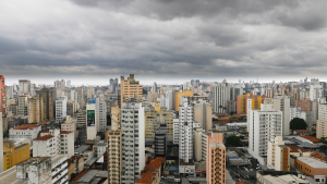 Vista panorâmica de Campinas com prédios residenciais e comerciais altos, ruas entre os edifícios e céu nublado ao fundo